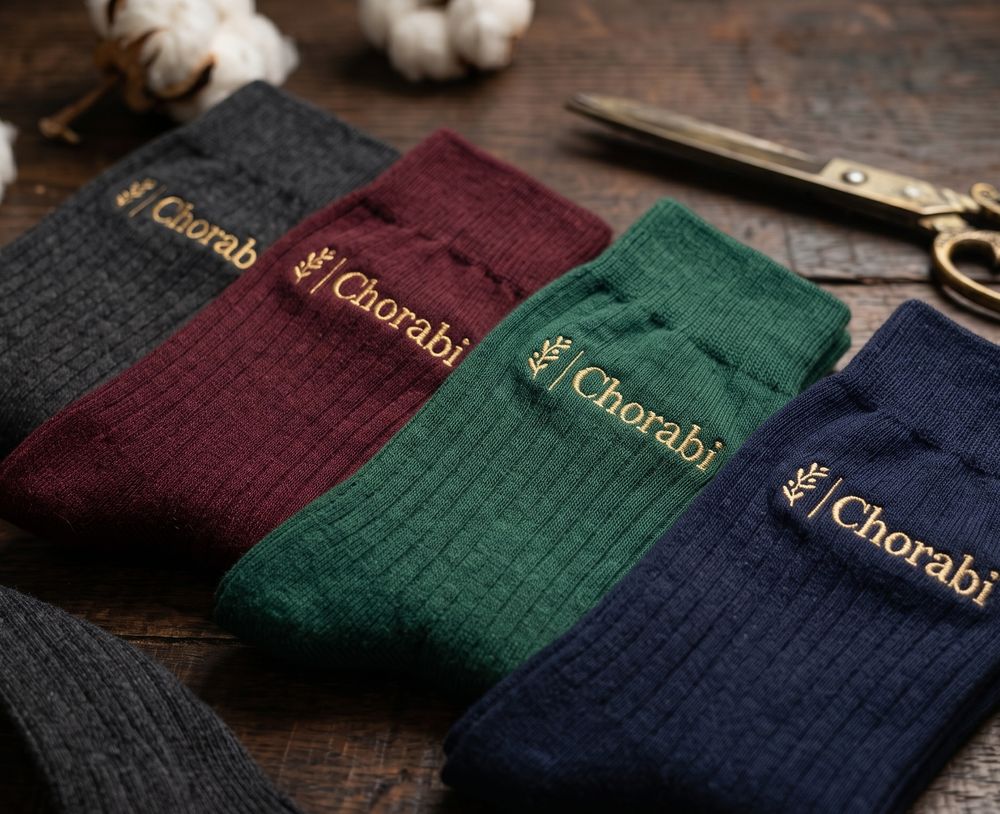 Four pairs of socks in anthracite, burgundy, green and navy with gold Chorabi embroidery
